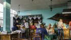 View of a restaurant in Cuba with the bar in the back left corner and people sitting at tables