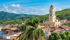 View of a historical building among luscious green hills and palm trees in Trinidad, Cuba